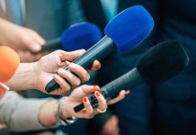 Reporters holding colorful microphones