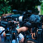Chemical Exposure at Iowa Prison Sends 15 to Hospitals TV news cameras crowding together at an outdoor event