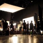 The New Tolkien Movie Is Already Dividing Hollywood film crew silhouetted on a studio set with bright lights