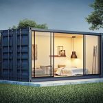 shipping container home with glass walls at dusk