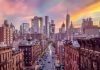 City street leading to a modern skyline at sunset