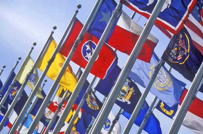 shutterstock_139254692-1 A row of various flags waving in the wind against a clear blue sky