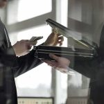 Two men in suits exchanging cash and a briefcase