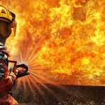 Evacuate Now: What Ignited Reno’s Inferno? Firefighter spraying water at a large blaze