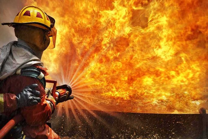 shutterstock_141560836 Firefighter spraying water at a large blaze
