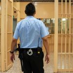 NFL Chaos: A Star Faces Dark Accusations corrections officer walking through prison corridor