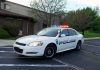 Police car with flashing lights parked outside a building