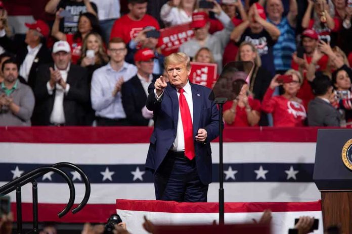 shutterstock_1651529632 man in suit points from a stage at a political rally