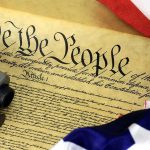 Supreme Court Delivers 9-0 Second Amendment Win in Marijuana Case Close-up of the U.S. Constitution with a firearm and American flag