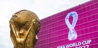 FIFA World Cup trophy in front of Qatar 2022 banner