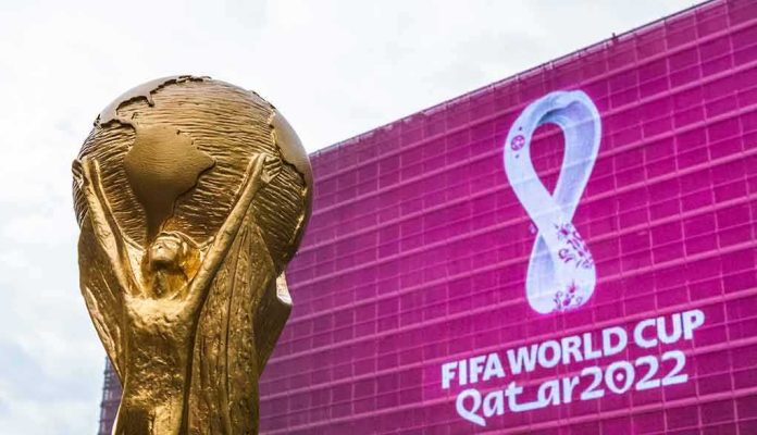 FIFA World Cup trophy in front of Qatar 2022 banner