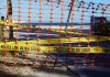 Orange safety net and yellow police tape blocking a beach access