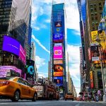 Times Square street with yellow taxi and bright billboards