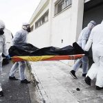 50+ Bodies Found Decomposing at Chicago Funeral Home medical team in hazmat suits carrying a body on a stretcher