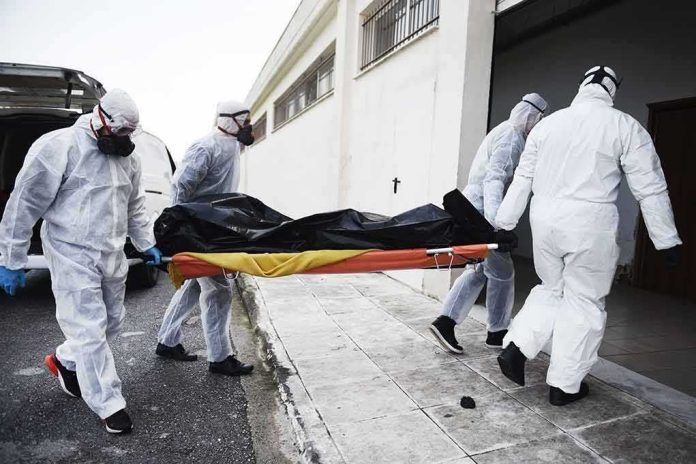 medical team in hazmat suits carrying a body on a stretcher