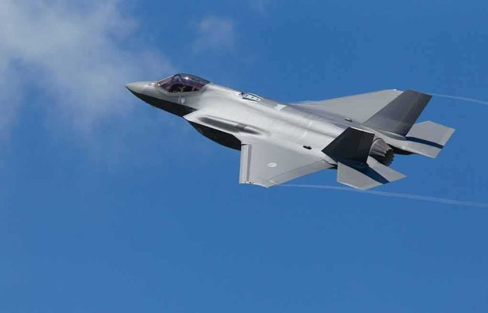 Stealth fighter jet banking in a clear blue sky
