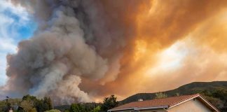 Suburban house under towering wildfire smoke plume