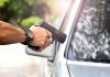 hands holding a handgun aimed near a car window