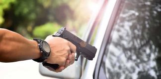 Austin Shooting Under Investigation hands holding a handgun aimed near a car window
