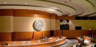 Data Center Debate Becomes Security Fight Interior view of a government chamber with wooden paneling and seating
