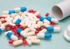 Assorted pills and capsules spilled from a bottle