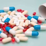 Assorted pills and capsules spilled from a bottle