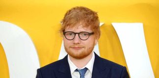Ed Sheeran Breaks His Silence on Gaza Ed Sheeran in a navy suit against a yellow backdrop