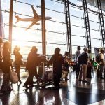 Midair Cockpit Attack Triggers Emergency Landing Passengers queue inside an airport terminal at sunset