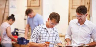 Students using tools in a workshop with instructor supervising