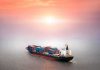 Container ship at sea under a hazy sunset