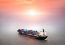 Container ship at sea under a hazy sunset