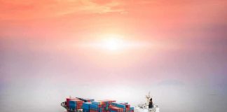 Container ship at sea under a hazy sunset