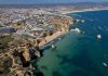 Coastal city with cliffs, beaches, and boats on turquoise water