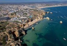 Coastal city with cliffs, beaches, and boats on turquoise water