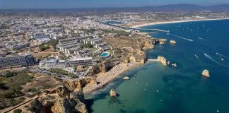 Coastal city with cliffs, beaches, and boats on turquoise water
