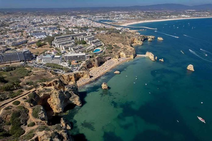 Coastal city with cliffs, beaches, and boats on turquoise water