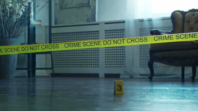 shutterstock_2196208533 Crime scene tape across a room with evidence marker on floor
