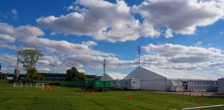 VIP Ghosting: Kentucky Event Canceled Five Days Early Temporary white tents and equipment on a grassy field with traffic cones and metal barriers
