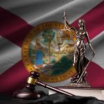Lady Justice statue with gavel and book before Florida state flag