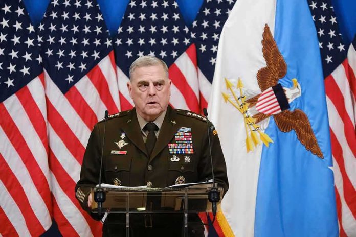 Military officer speaks at podium with U.S. flags behind