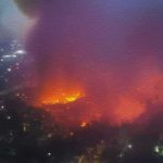Aerial view of large urban fire at night
