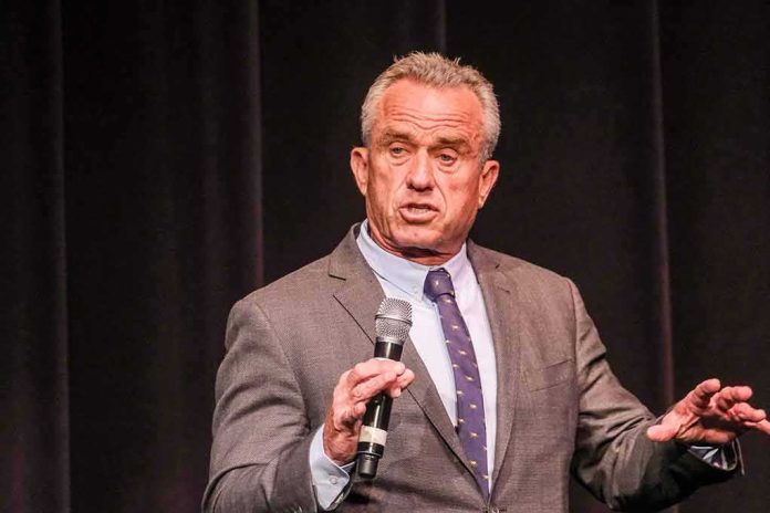shutterstock_2341983423 man in a suit speaking into a microphone on stage