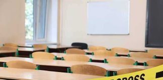 Empty classroom with police tape across desks