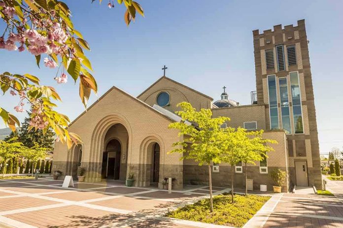 Brick church with arched entrance and tall bell tower on a sunny day