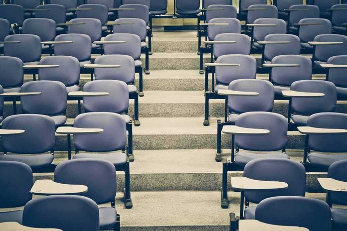 shutterstock_267441548 Empty lecture hall with rows of blue seats and foldable desks