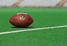 American football on a green field near a white line