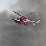 Rescue helicopter hovers amid thick smoke