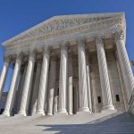 Supreme Court SMACKS Trump Order The Supreme Court building featuring grand columns and statues under a clear blue sky