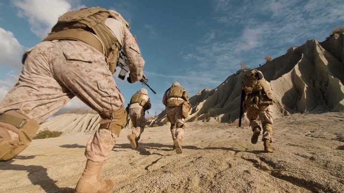 shutterstock_675995377-1 Soldiers in desert camouflage running across rocky terrain