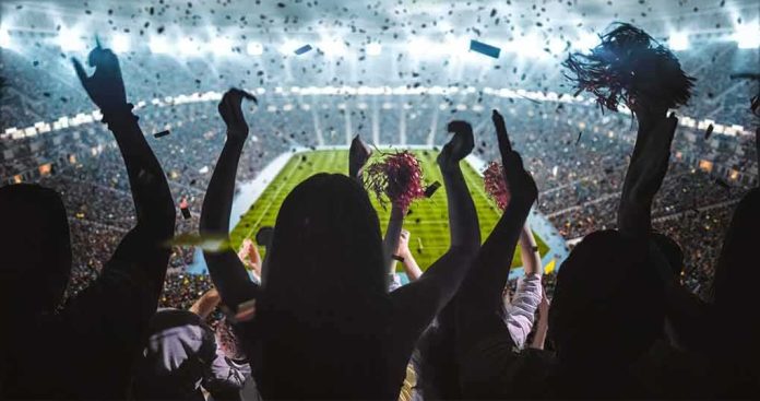 Fans cheering in a packed stadium during a night game